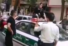 نشستن یک زن روی سقف ماشین پلیس در تهران  + فیلم